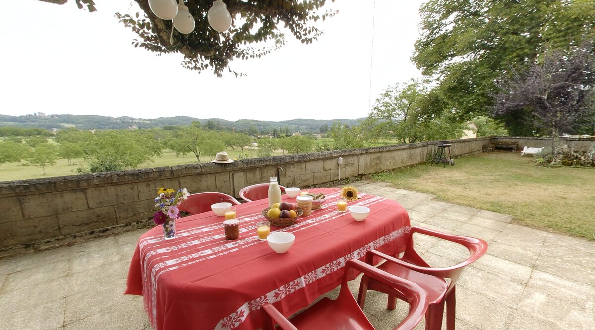 Terrasse de la Grande Paponie avec vue sur le jardin, offrant un espace convivial pour se détendre en plein air