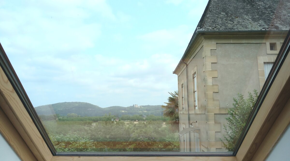Vue du château de Fenelon, visible depuis la salle à manger, entouré de verdure